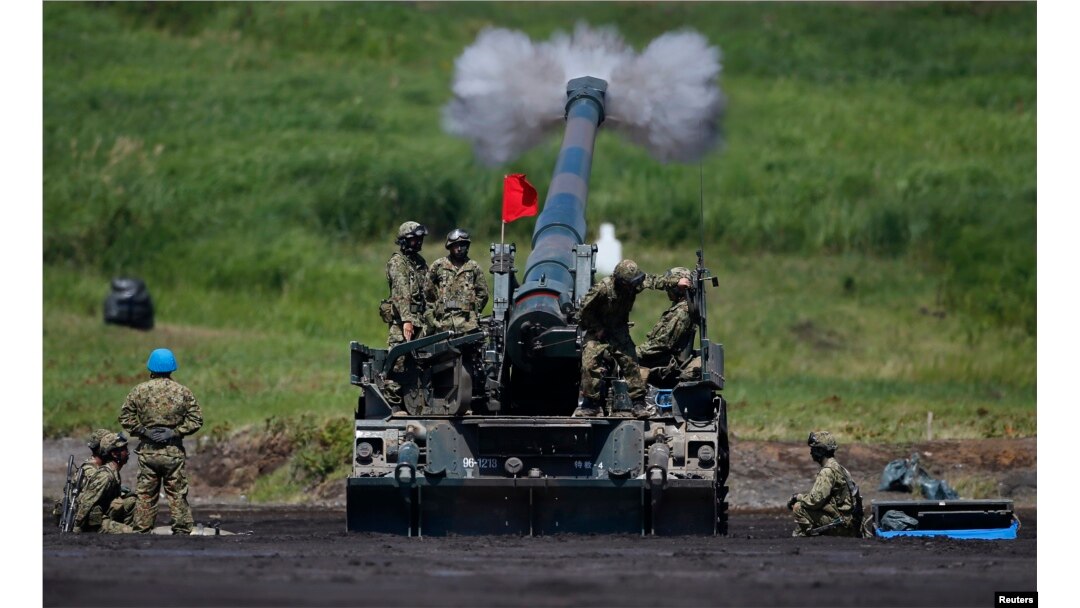FILE - Japanese Ground Self-Defense Force soldiers fire a self-propelled howitzer during annual exercises near Mount Fuji at Higashifuji training field in Gotemba, west of Tokyo.