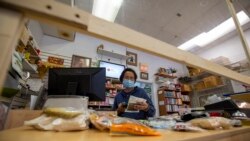 Nattha Teppitak scans groceries to complete orders at the Thai Shop grocery store in Springfield, VA April 26, 2020.