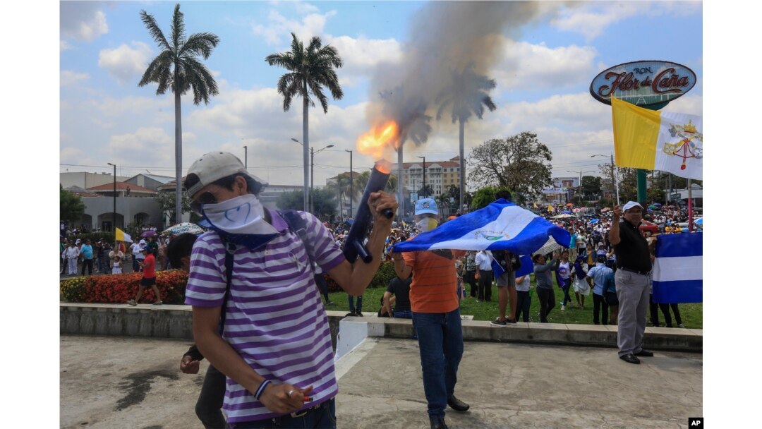 An anti-government protester fires a homemade mortar on the sidelines of a Stations of the Cross procession on Good Friday in Managua, Nicaragua, April 19, 2019.