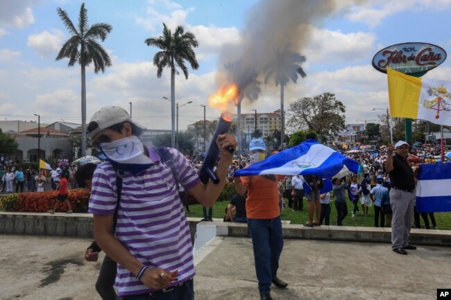 An anti-government protester fires a homemade mortar on the sidelines of a Stations of the Cross procession on Good Friday in Managua, Nicaragua, April 19, 2019.