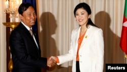 Speaker of Myanmar's Lower House of Parliament Thura Shwe Mann (L) shakes hands with Thailand's Prime Minister Yingluck Shinawatra during his visit to Thailand at the Government House in Bangkok, Sept. 23, 2013.