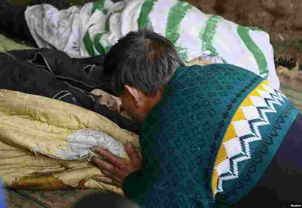 A local resident kisses the body of a friend, who was killed in an&nbsp;overnight&nbsp;gunfight near the city of Slaviansk, April 20, 2014.&nbsp;