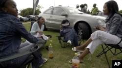 Township residents picnic beside luxury vehicles in Soweto's Thokoza Park. South Africa's black middle class is fueling a consumer boom (File Photo)