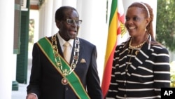 FILE: Zimbabwe President Robert Mugabe stands with his wife Grace, as they pose for a photo at State House in Harare, Oct, 28, 2014. 