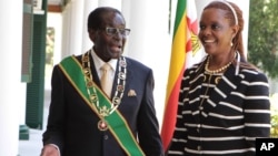Zimbabwe President Robert Mugabe stands with his wife Grace, as they pose for a photo at State House in Harare, Oct, 28, 2014. 