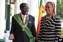 FILE - Zimbabwe President Robert Mugabe stands with his wife Grace, as they pose for a photo at State House in Harare.
