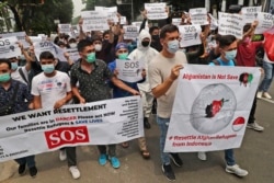 Pengungsi Afghanistan yang tinggal di Indonesia memegang poster dalam aksi unjuk rasa di luar gedung kantor perwakilan UNHCR di Jakarta, 4 Oktober 2021.