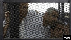 ຈາກຊ້າຍ ທ່ານ Peter Greste, Mohamed Fahmy ແລະ ທ່ານ Baher Mohamed ກຳລັງຟັງການຕັດສິນ ຢູ່ສານ ໃນນະຄອນໄຄໂຣ