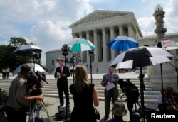 Numerous news crews wait outside the Supreme Court, which is expected to rule on several key cases yet this term, in Washington, June 25, 2014.