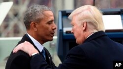 Presiden AS Donald Trump dan pendahulunya, Barack Obama, dalam upacara pelantikan dirinya Januari 2017. 