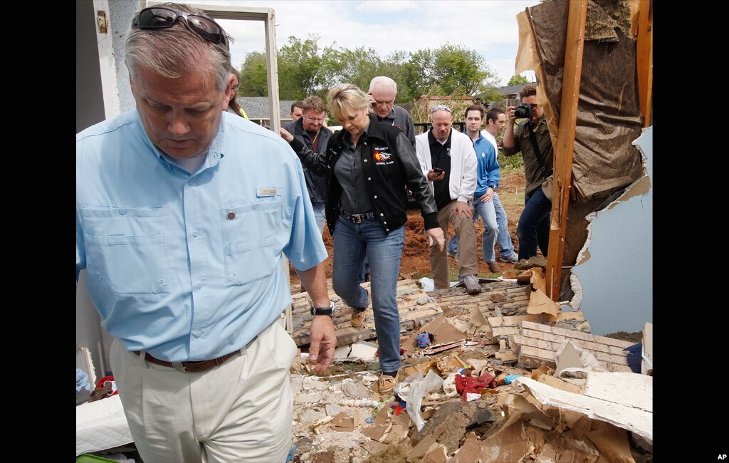 John Doak, left, Oklahoma Insurance Commissioner, and Oklahoma Gov. Mary Fallin, center, tour a tornado damaged home in Woodward, Oklahoma April 15, 2012. Residents of several states scoured through the wreckage of battered homes and businesses after doze