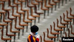 A Swiss guard adjusts a face mask ahead of the weekly general audience held by Pope Francis, in Aula Paolo VI at the Vatican.
