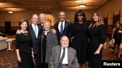 Mantan Presiden AS George H.W. Bush (tengah di kursi roda) bersama putranya yang juga mantan Presiden AS dan mantan Ibu Negara (Kiri-Kanan) Laura Bush, George W. Bush, Bill Clinton, Hillary Clinton, Barack Obama, Michelle Obama, dan Ibu Negara Melania Trump, berfoto pada acara pemakaman mantan Ibu Negara Barbara Bush di Houston, Texas, 21 April 2018.