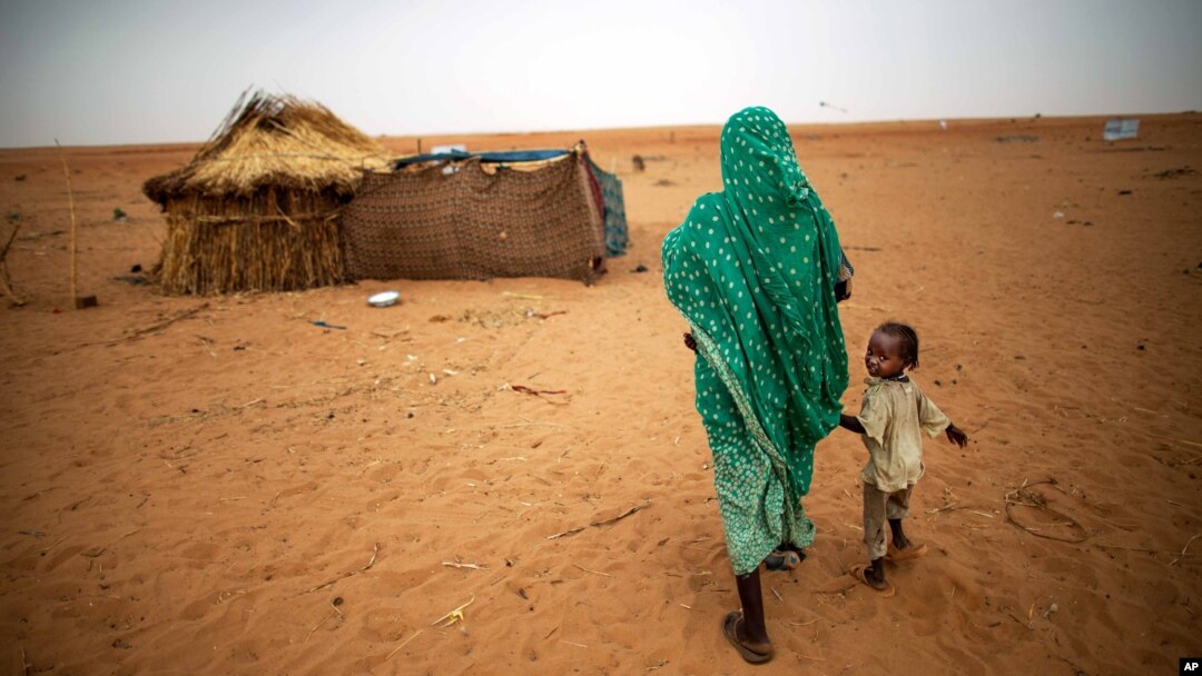ARSIP – Foto yang dirilis oleh United Nations African Union Mission in Darfur (UNAMID) menunjukkan gambar seorang wanita yang bergandengan tangan dengan anak perempuannya sambil berjalan di kamp pengungsi Zam Zam untuk mereka yang tersingkir di Darfur Utara, Sudan. (foto: AP Photo/UNAMID, Albert Gonzalez Farran)