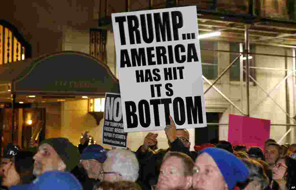 Protesters hold signs at an anti-Trump rally hosted by filmmaker Michael Moore, Jan. 19, 2017, in New York. 