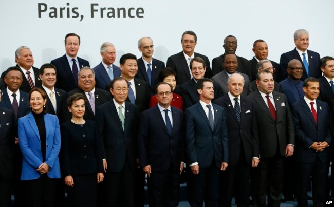 FILE - French President Francois Hollande, front center, poses with world leaders for a group photo as part of the COP21, United Nations Climate Change Conference, in Le Bourget, outside Paris, Nov. 30, 2015.