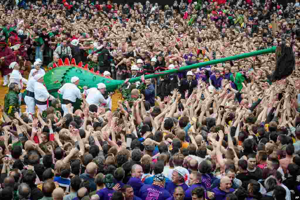 People gather at the Grand Place in Mons, Belgium, during the Ducasse (Doudou). The Ducasse is a popular medieval festival that holds every year on Trinity Sunday and depicts the fight between Saint George, representing the good, and the dragon, the evil. Spectators are taking part by trying to catch the mane from the tail of the dragon which is believed to give luck for one year.