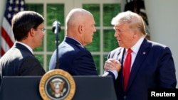 Le président américain Donald Trump saluant le général de l'armée de l'air John Raymond, commandant du SPACECOM, en présence du secrétaire à la Défense Mark Esper, lors du lancement officiel du commandement spatial américain à la Maison Blanche, le 29 août 2019.