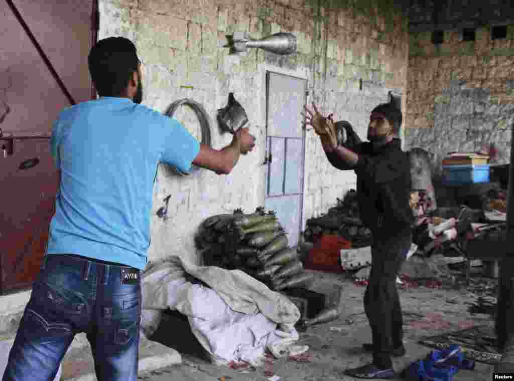 A Free Syrian Army fighter throws a mortar shell to a fellow fighter in Jabal al-Akrad area in Syria's northwestern Latakia province, Nov. 6, 2013.