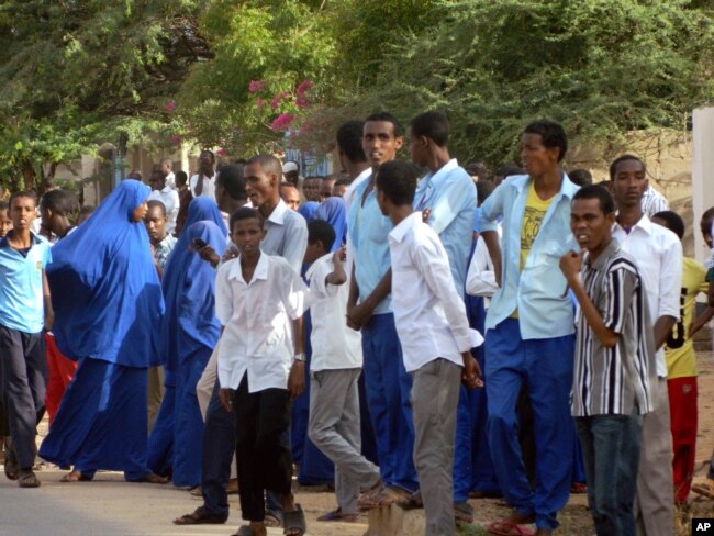 FILE - Students gather and watch from a distance outside the Garissa University College after an attack by gunmen, in Garissa, Kenya, Thursday, April 2, 2015. Gunmen attacked the university early Thursday, shooting indiscriminately in campus hostels. Police and