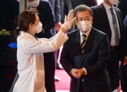 韩国总统文在寅戴着口罩在首尔的国会议事堂接受体温检测。（2020年2月28日）