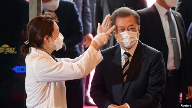 韩国总统文在寅戴着口罩在首尔的国会议事堂接受体温检测。（2020年2月28日）