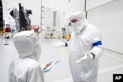 FILE - Principal Investigator for NASA's Lucy spacecraft, Hal Levison, right, speaks with a reporter at the AstroTech facility, in Titusville, Fla., Sept. 29, 2021.