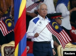 Malaysia's Prime Minister Najib Razak waves a Malaysian national flag during National Day celebrations in Kuala Lumpur, August 31, 2015.