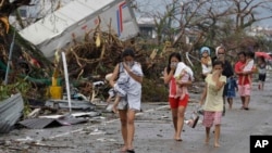 Warga yang selamat dari topan Haiyan di Tacloban, pulau Leyte menutup hidung akibat bau menyengat mayat para korban tewas (10/11). 