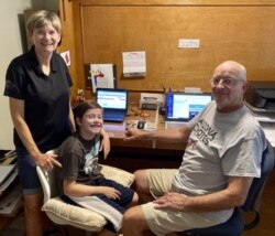 Mary and Bill Hill are pictured with their 8-year-old grandson Will in suburban Phoenix, Arizona. They oversee his distance learning. (Bill Hill via AP)