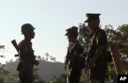 FILE - Three soldiers patrol along a mountain near Laiza, Kachin State, Myanmar, Nov. 30, 2016.