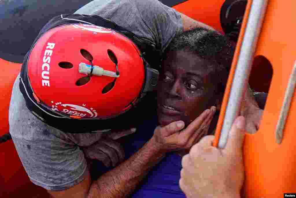 A crew member of NGO Proactiva Open Arms rescue boat embraces African migrant in central Mediterranean Sea, July 17, 2018.