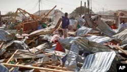 A shopkeeper surveys the wreckage of shops destroyed by a blast in a market in the capital Mogadishu, Somalia, Feb. 19, 2017. 