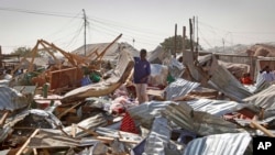 索马里首都摩加迪沙的一个忙碌的市场发生爆炸后，商店店员检查废墟（2017年2月19日）