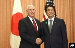 FILE - Japanese Prime Minister Shinzo Abe, right, and U.S. Vice President Mike Pence shake hands prior to a luncheon hosted by Abe at the prime minister's official residence in Tokyo, April 18, 2017.
