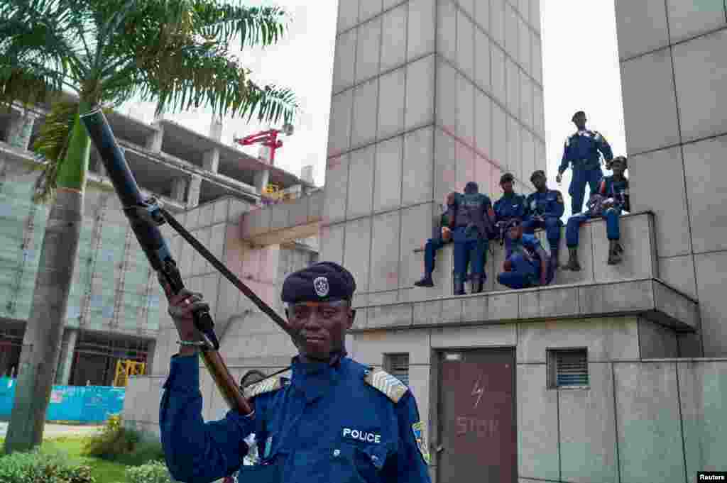 Des policiers congolais assis sur le bâtiment de la gare centrale, à Gombe, Kinshasa, en RDC, le 19 décembre 2016.