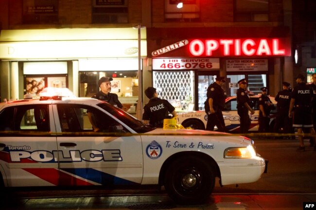 Police officers walk the scene at Danforth St. at the scene of a shooting incident, in Toronto, Canada, July 22, 2018.