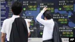 Papan harga saham elektronik di sebuah perusahaan sekuritas di Tokyo (23/7). Harga saham Asia anjlok seiring kekhawatiran baru atas krisis di Eropa dan melambatnya pertumbuhan perekonomian di Tiongkok (AP Photo/Koji Sasahara).