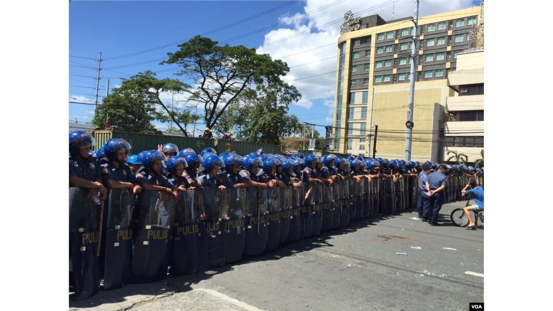 Hundreds of Philippine riot police wall-off a road that leads to the main retreat hall, some kilometers away, of the Asia-Pacific Economic Cooperation leaders. Pasay City, Metro Manila, Philippines, Nov. 19, 2015. (S. Orendain/VOA)