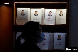 一名妇女走过北京一家书店陈列的习近平著作 (2021年3月1日)