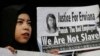 A supporter of Indonesian maid Erwiana Sulistyaningsih, holds a placard as Sulistyaningsih arrives at a court in Hong Kong, Feb. 10, 2015.