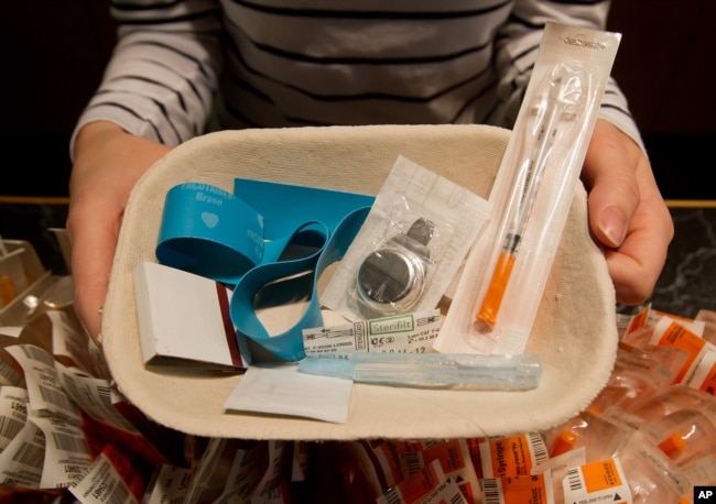 FILE - Registered nurse Sammy Mullally holds a tray of supplies to be used by a drug addict at the Insite safe injection clinic in Vancouver, B.C., Canada.