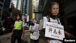 A pro-democracy protester, wearing a mask depicting a Chinese political prisoner calls for the release of political prisoners in Hong Kong, Oct. 1, 2013. 