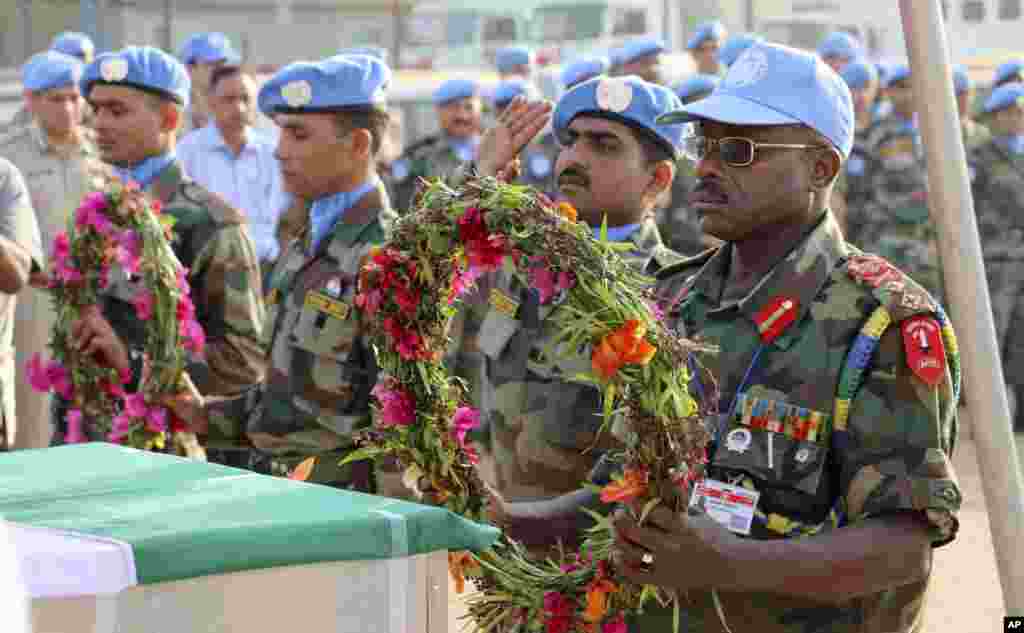 Force Commander Maj. Gen. Delali Sakyi of Ghana prepares to lay flowers on the coffins of his two colleagues who were killed on Dec. 19, 2013, at a memorial service held in the United Nations Mission in Juba, South Sudan, Dec. 21, 2013. 