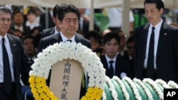 Japanese Prime Minister Shinzo Abe holds a wreath during a ceremony to mark the 70th anniversary of the Nagasaki atomic bombing in Nagasaki, southern Japan, Aug. 9, 2015. 