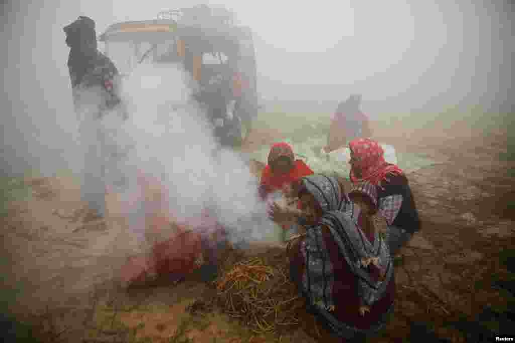 People gather near the fire to keep themselves warm during the &quot;Gadhimai Mela&quot; festival held in Bariyarpur, Nepal. The festival, known for its large number of animal sacrifices, is held every five years at the Gadhimai Temple.