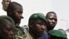 Lieutenant Amadou Konare, centre, spokesman for coup leader Amadou Haya Sanogo, unseen, is surrounded by security as he arrives to address supporters, as thousands rallied in a show of support for the recent military coup, in Bamako, Mali, March 28, 2012.