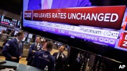 The rate decision of the U.S. Federal Reserve appears on a television screen, on the floor of the New York Stock Exchange, in New York City, Sept. 20, 2017.