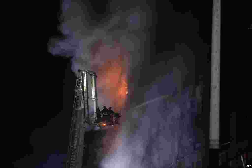 Firefighters work to put out a massive fire that broke out in a drink and food factory in Narayanganj, central Bangladesh.