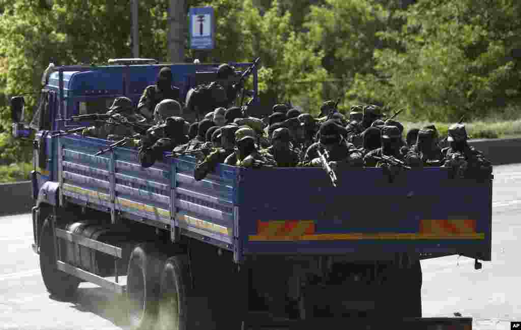 Pro-Russian militia men arrive to take positions outside an airport in Donetsk, Ukraine, May 26, 2014. 